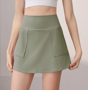 Dettaglio della gonna pantalone da yoga a vita alta con ampie tasche in verde salvia