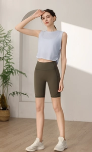 Dettaglio del crop top sportivo senza maniche azzurro e pantaloncini da ciclista verde oliva