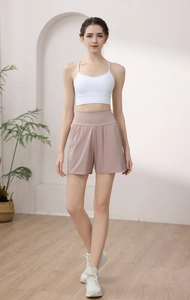 Detail of high waist yoga shorts and white sports bra on a model in a modern room