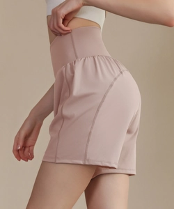 Détail du short de yoga taille haute rose poudré avec tissu lisse et coutures