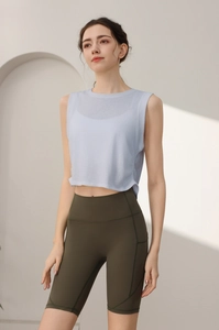 Dettaglio del gilet fitness senza maniche azzurro e pantaloncini da yoga oliva a vita alta