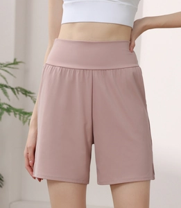 Détail d'un short de sport rose à taille haute montrant le tissu en nylon et la large ceinture