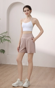 Detail view of high waisted workout shorts with functional side pockets in soft pink