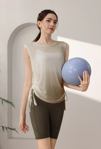 Detail of gradient sleeveless yoga top with side drawstrings and green biker shorts