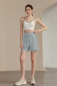Gros plan d'un short de yoga ample et d'un caraco blanc sur mannequin en studio