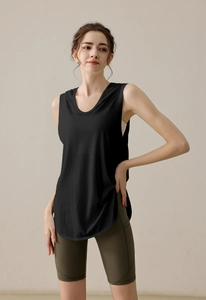 Close-up of a loose black sleeveless gym vest with curved hem and olive green yoga shorts