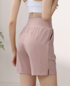 Detail view of high-waisted pink sports shorts with side pockets and slimming back seam