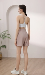 Detailed side view of high-waisted shorts and cross-back sports bra for yoga and fitness