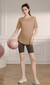 Détail du haut de sport camel avec découpe épaule élégante pour séances de yoga