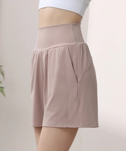 Detail of high-waisted yoga shorts in dusty rose with side pocket and loose fit cut