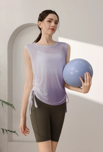 Close-up of lightweight purple yoga tank top with side drawstrings and green cycling shorts