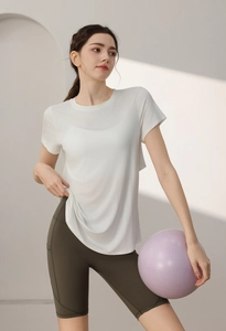Detail of white modal sports tee and olive green cycling shorts with fitness ball