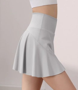 Dettaglio della gonna-pantalone sportiva a pieghe grigio chiaro con vita alta per tennis e yoga