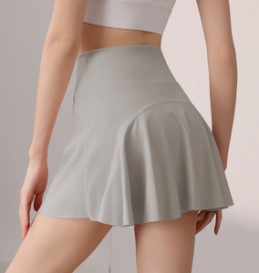 Detailansicht eines hellgrauen Tennisrockes mit hoher Taille und Faltenwurf von der Seite