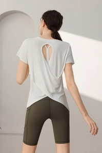 Detail of white modal sports top with back cutout and stylish crossed hem design
