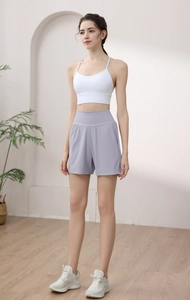 Detail of high waisted light purple yoga shorts and white sports bra on a model