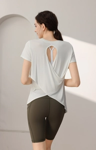 Detail of white modal sports top with back cutout and crisscross layered design