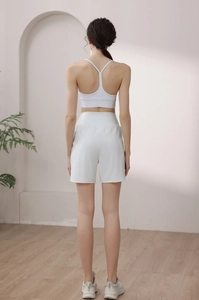Vue arrière du short de sport ample blanc à taille haute et brassière dos en Y