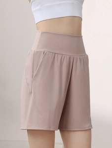 Detail view of high-waisted pink sports shorts featuring wide waistband and side pockets