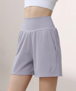 Detail of high-waisted yoga shorts in light purple with functional side pockets