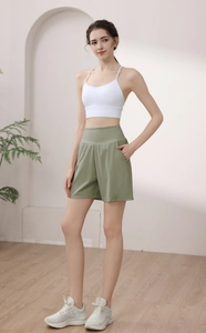 Detail of high-waisted green sports shorts with side pockets and moisture-wicking fabric