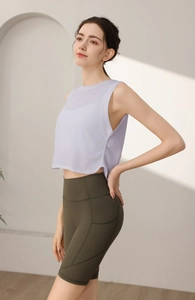 Dettaglio del top sportivo lilla senza maniche e pantaloncini fitness oliva a vita alta