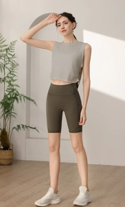 Dettaglio top sportivo grigio senza maniche con coulisse e pantaloncini da ciclista verdi