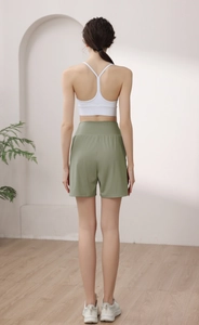 Back view of white Y-back sports bra and high-waisted olive green fitness shorts