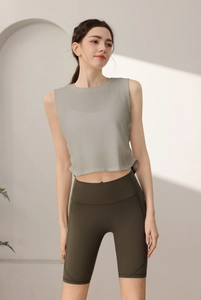 Dettaglio delle pieghe laterali con coulisse sul crop top da yoga grigio senza maniche