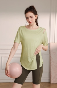 Détail du haut de yoga vert clair avec découpe à l'épaule et fente latérale à l'ourlet