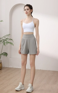 Detail of high waisted grey yoga shorts with side pockets on a fitness model