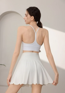 Macro view of white pleated sports skirt showing dense pleats and back strap details