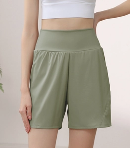Detail view of olive green high-waisted sports shorts with wide waistband and loose fit