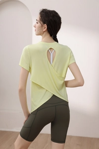 Detail view of open back yoga t-shirt with crossover hem and pocket cycling shorts