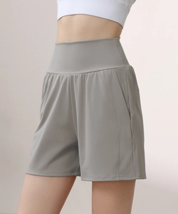 Detail of high waisted compression yoga shorts with side pockets in grey nylon fabric