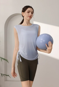 Detail view of light blue sleeveless gym top with side drawstring and green yoga shorts