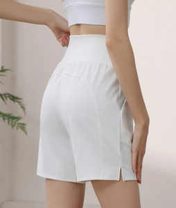 Macro detail of high-waisted white sports shorts showing curved back seams and side slits