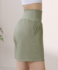 Detail view of olive green high-waisted fitness shorts with side pockets and smooth seams