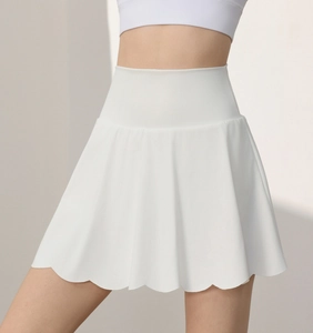 Detail of high waisted white tennis skirt with scalloped hem for fitness and yoga