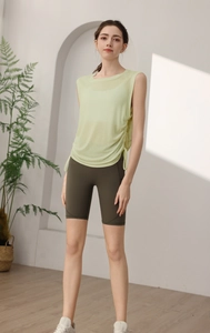 Detail of light green yoga top with side drawstring ruching and high waist olive shorts