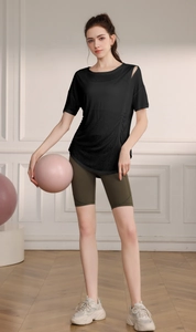Détail du haut de yoga noir semi-transparent avec épaule évidée et plis latéraux