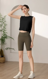 Dettaglio del top sportivo nero senza maniche e pantaloncini da yoga a vita alta oliva