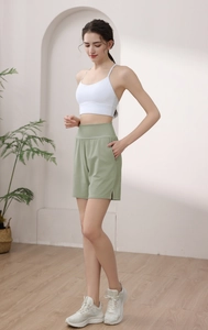 Women high waisted green sports shorts with side pockets and split hem detail