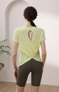 Detail of cross-back yoga shirt with drop cutout and high-waist biker shorts