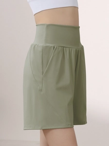Side view of high-waisted olive green sports shorts with convenient side pockets