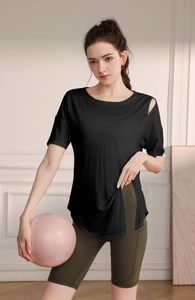 Détail du t-shirt de yoga noir ample avec épaule découpée et fente latérale pour le pilates