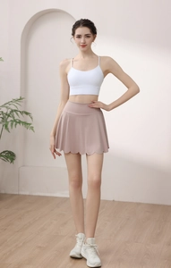Detailed view of dust pink yoga skirt with laser-cut scalloped hem and built-in shorts