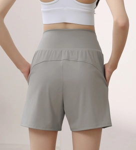 Detail of high waisted grey yoga shorts with curved stitching and side pockets for women