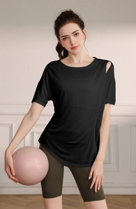 Détail du haut de yoga noir ajouré avec cordons latéraux et short de sport vert olive