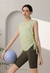 Detail of light green yoga tank top with side drawstring design and olive green shorts